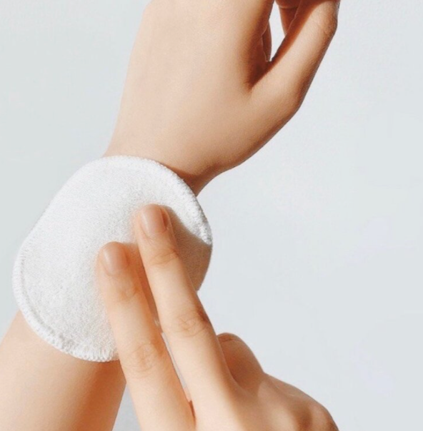ID: a hand holding a Meiyu makeup wipe against a wrist